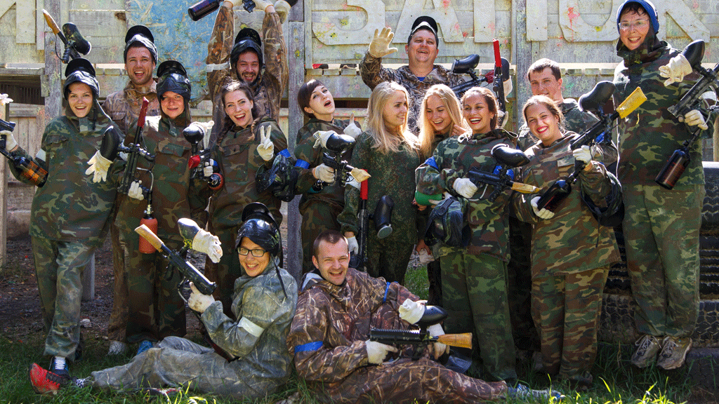 Animateur expliquant les consignes de sécurité à un groupe de collaborateurs avant une session de paintball